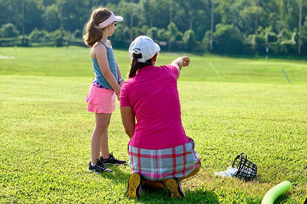 junior golfer getting advised from trainer